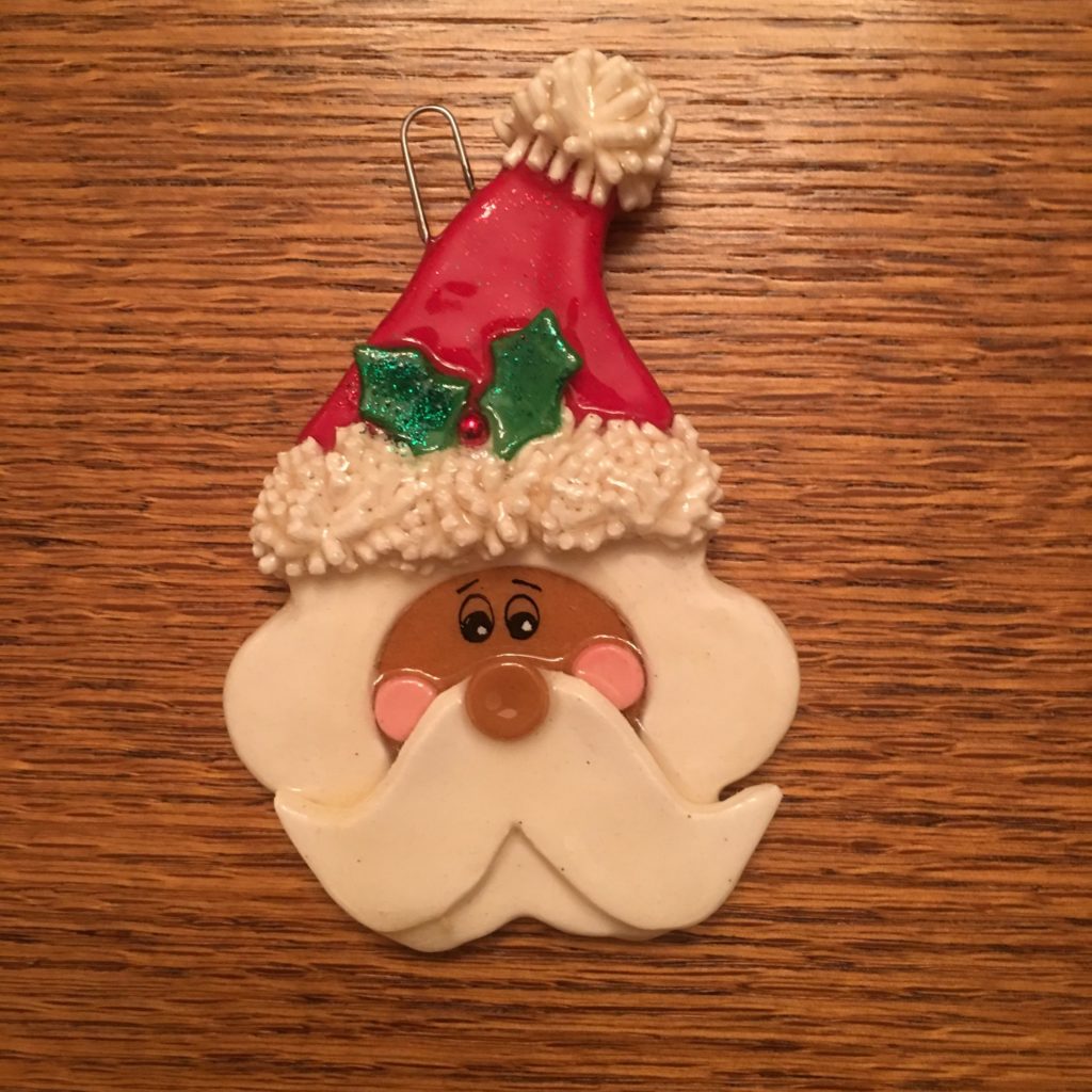 A santa clause cookie is sitting on the table.