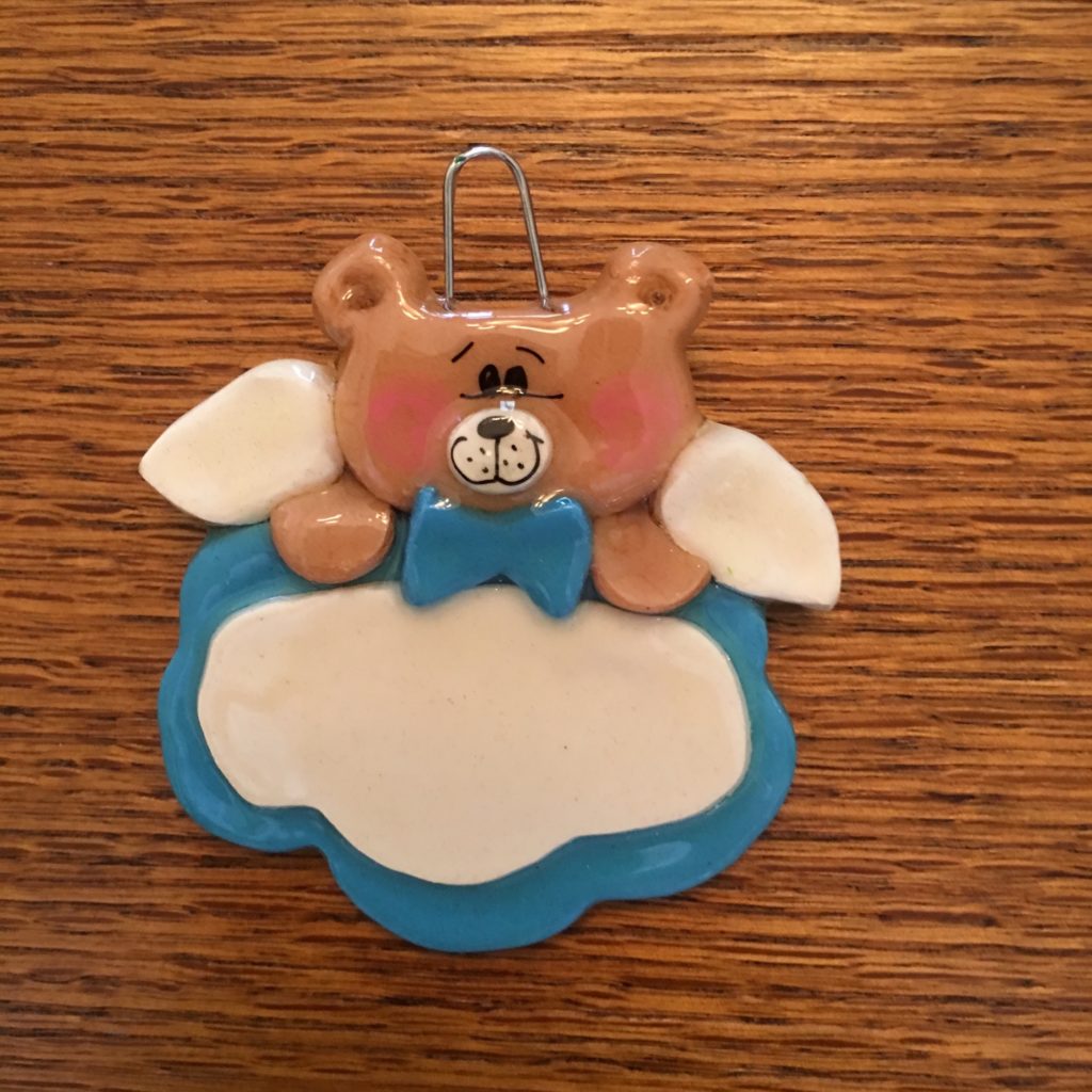 A bear with wings and blue bow tie.