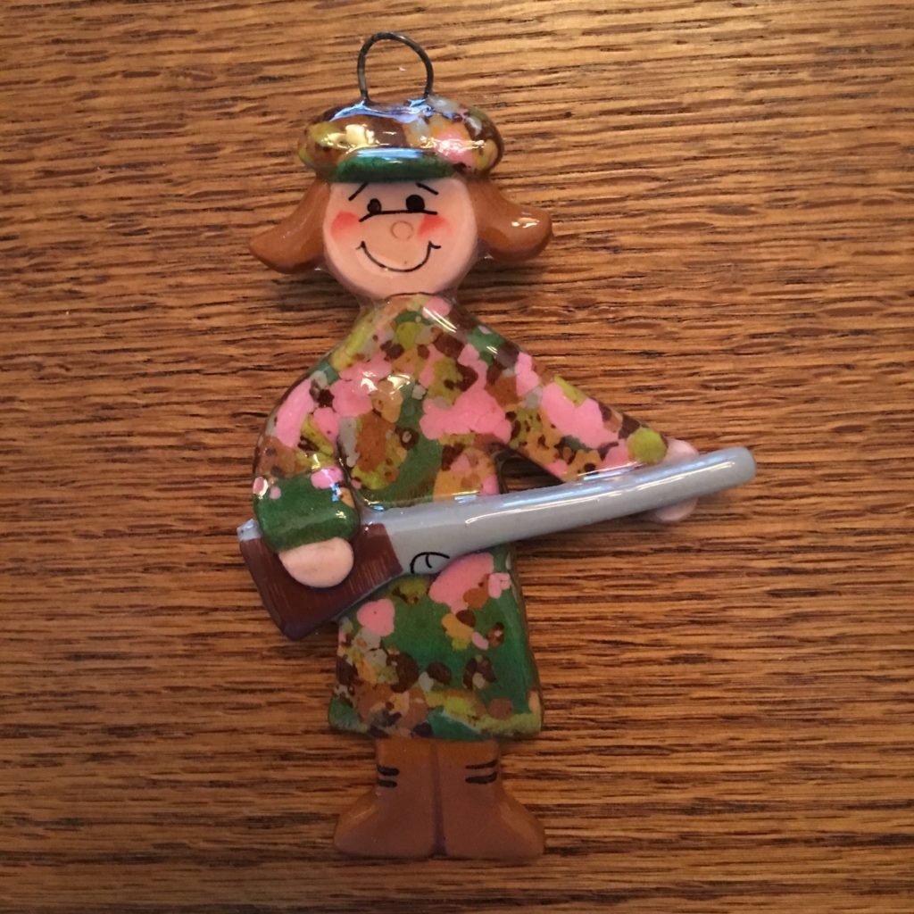 A wooden doll with a baseball cap and a bat.
