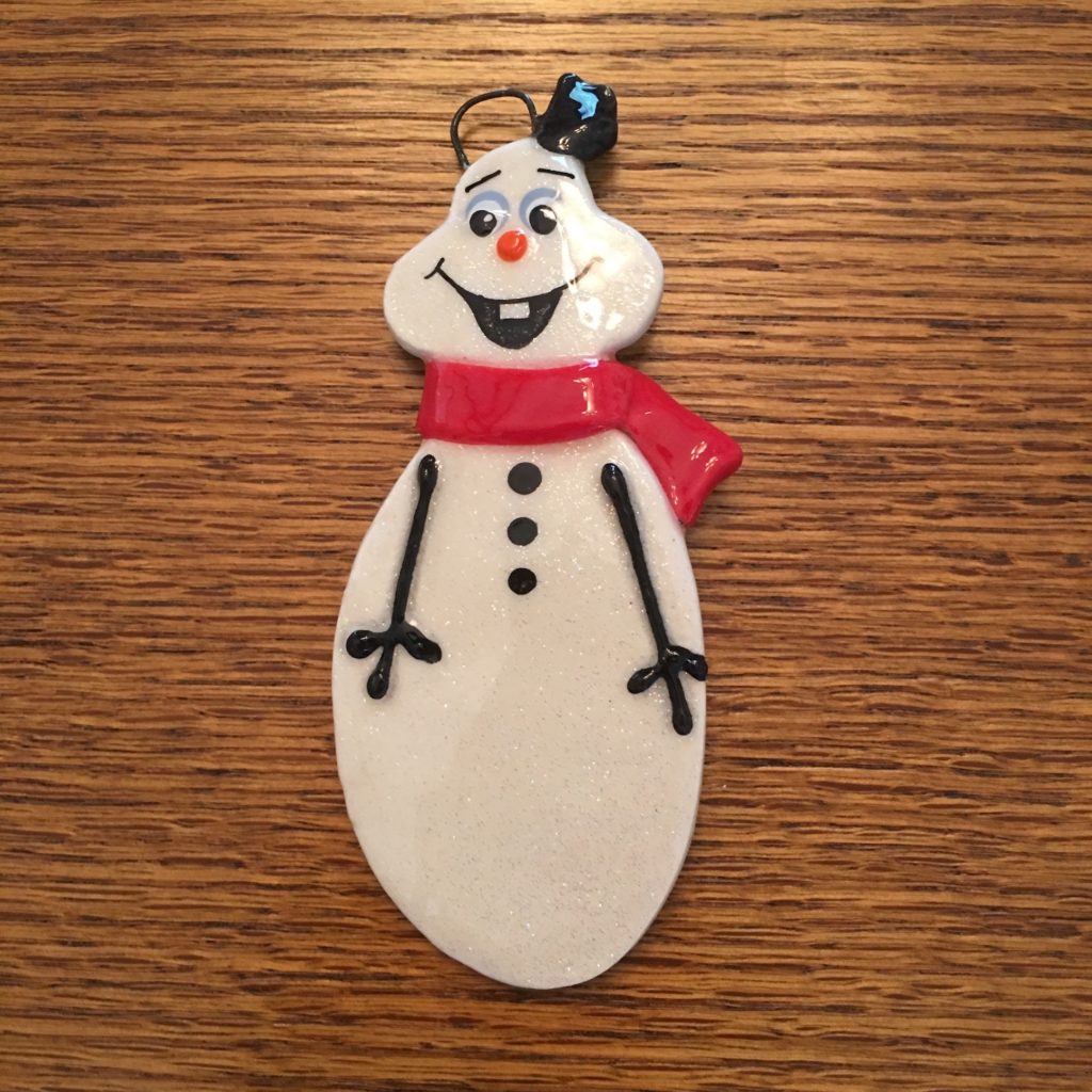 A snowman ornament is sitting on top of a table.