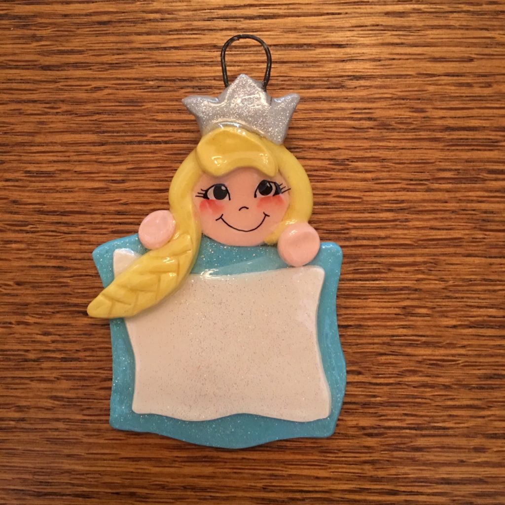 A blonde haired girl ornament with a crown on her head.