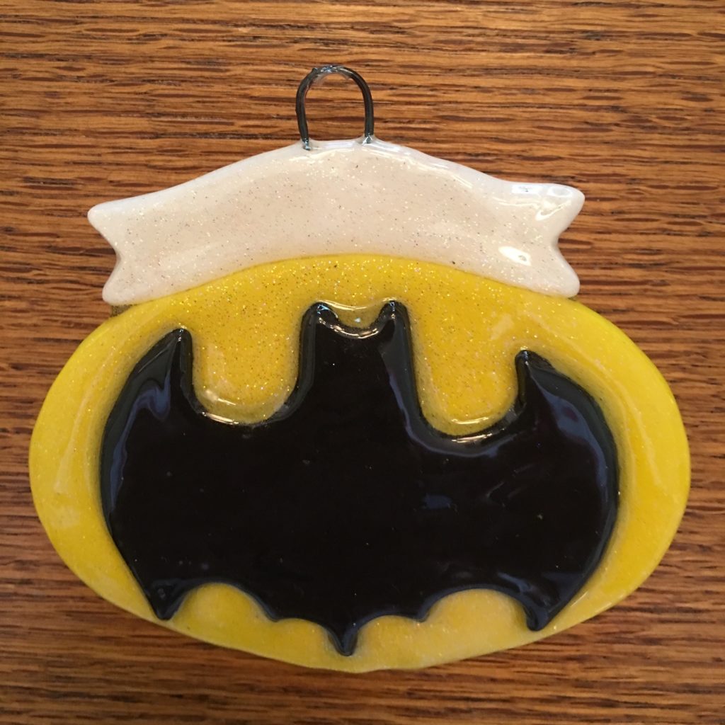 A batman ornament is hanging on the wall.