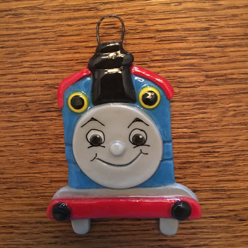 A thomas the tank engine keychain is sitting on top of a table.