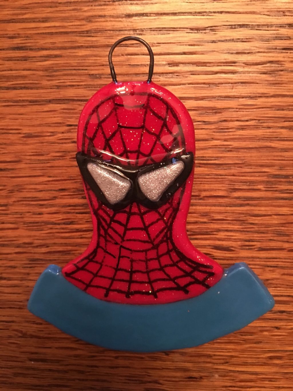 A spider man ornament hanging on the wall.