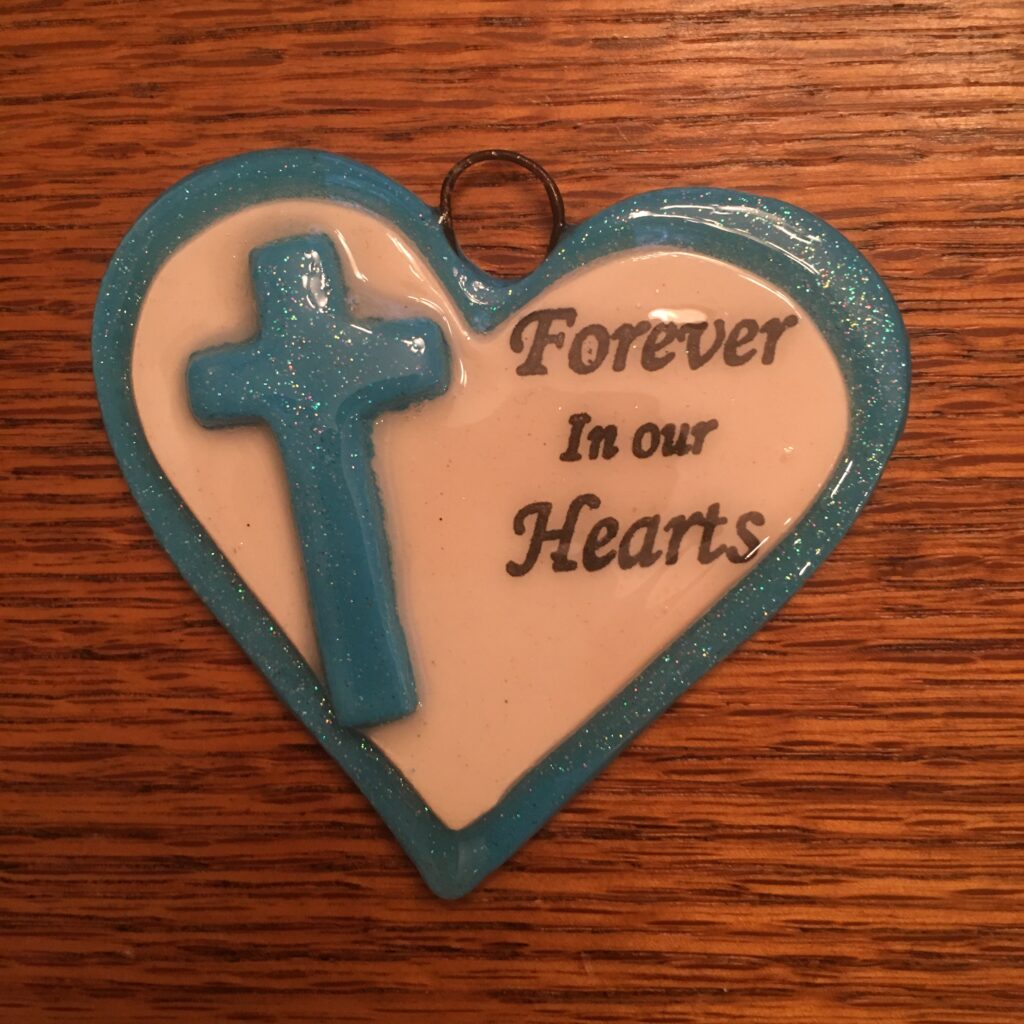 A blue and white heart with the words " forever in our hearts ".