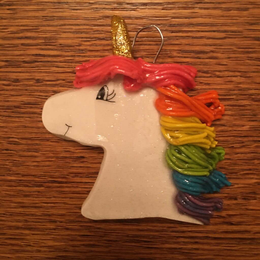 A white unicorn ornament with rainbow hair.