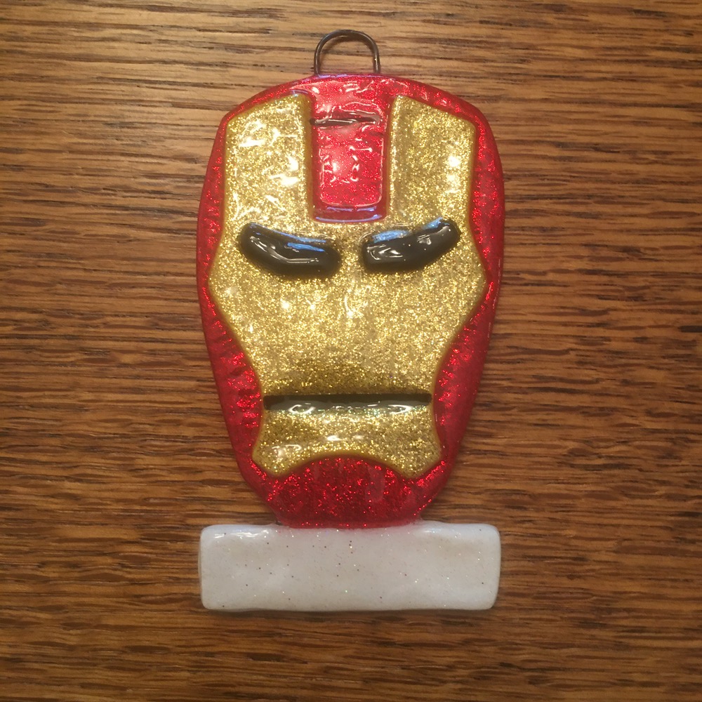 A red and gold iron man mask on top of a wooden table.