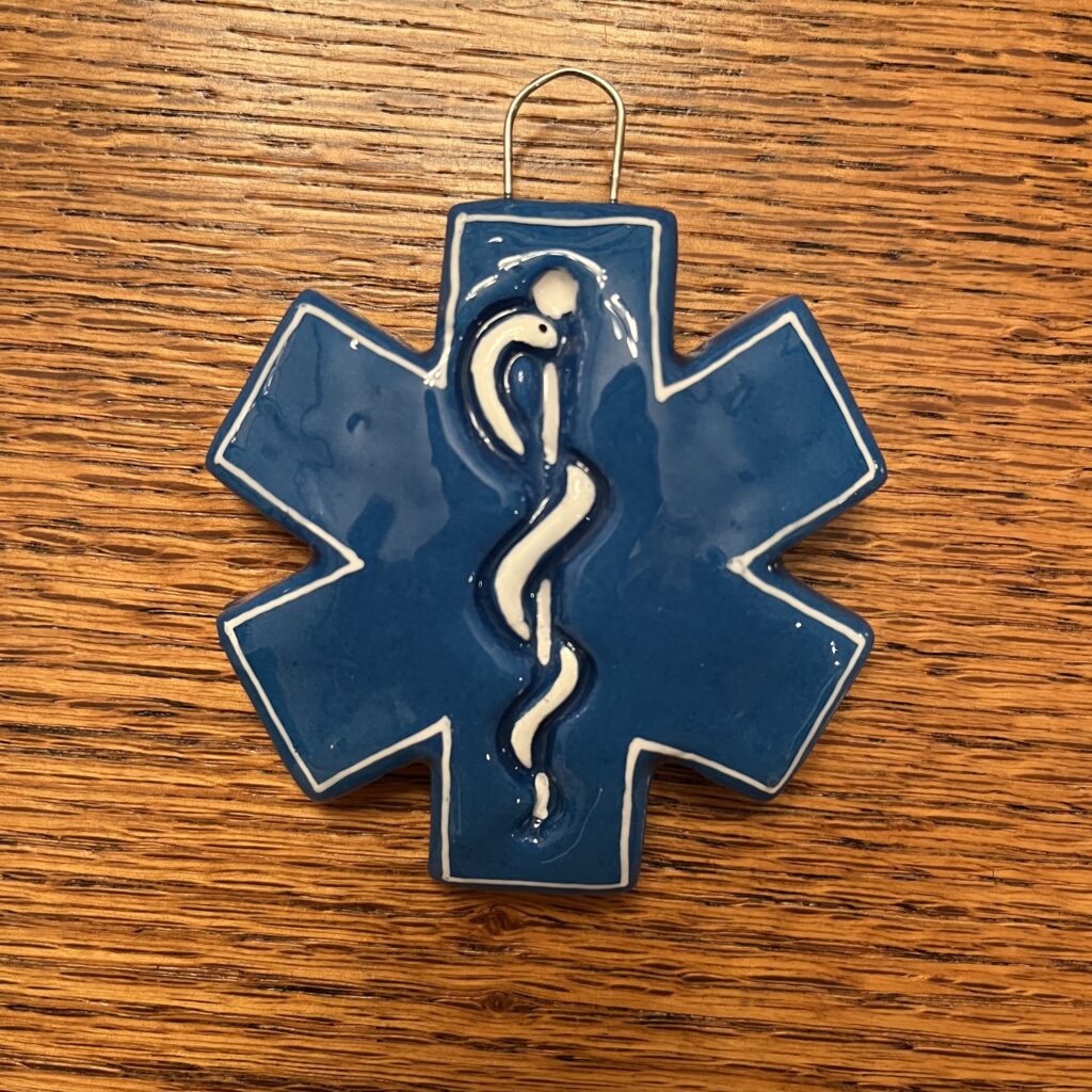 A blue star of life ornament on top of a wooden table.