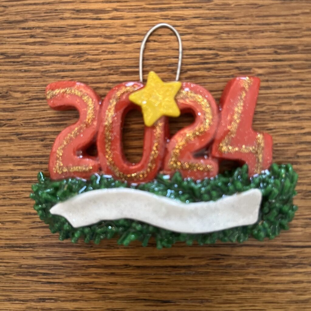 A red and gold ornament with the number 2 0 2 4.