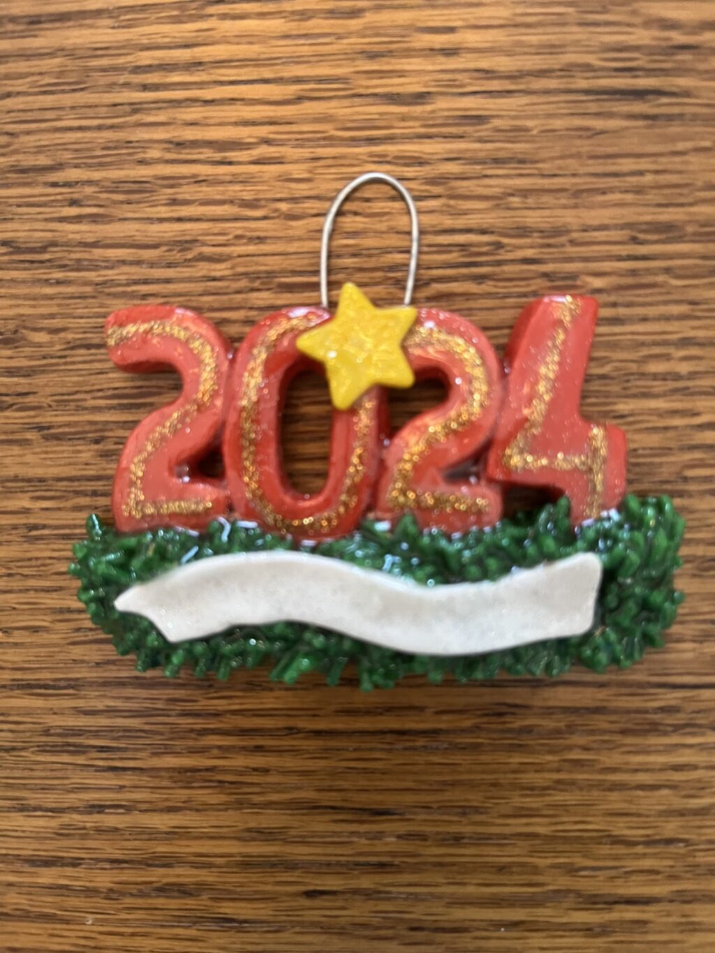 A red and gold ornament with the number 2 0 2 4.