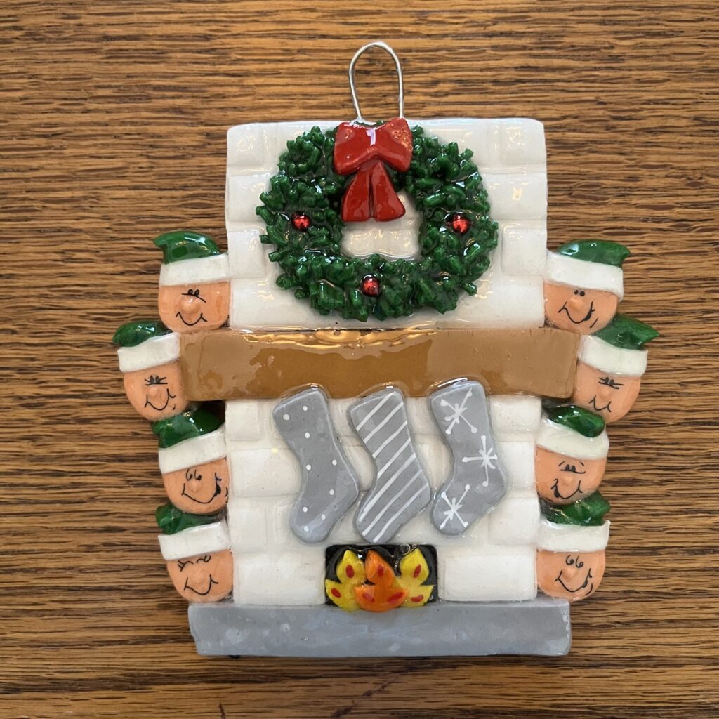 A christmas ornament with a fireplace and stockings.